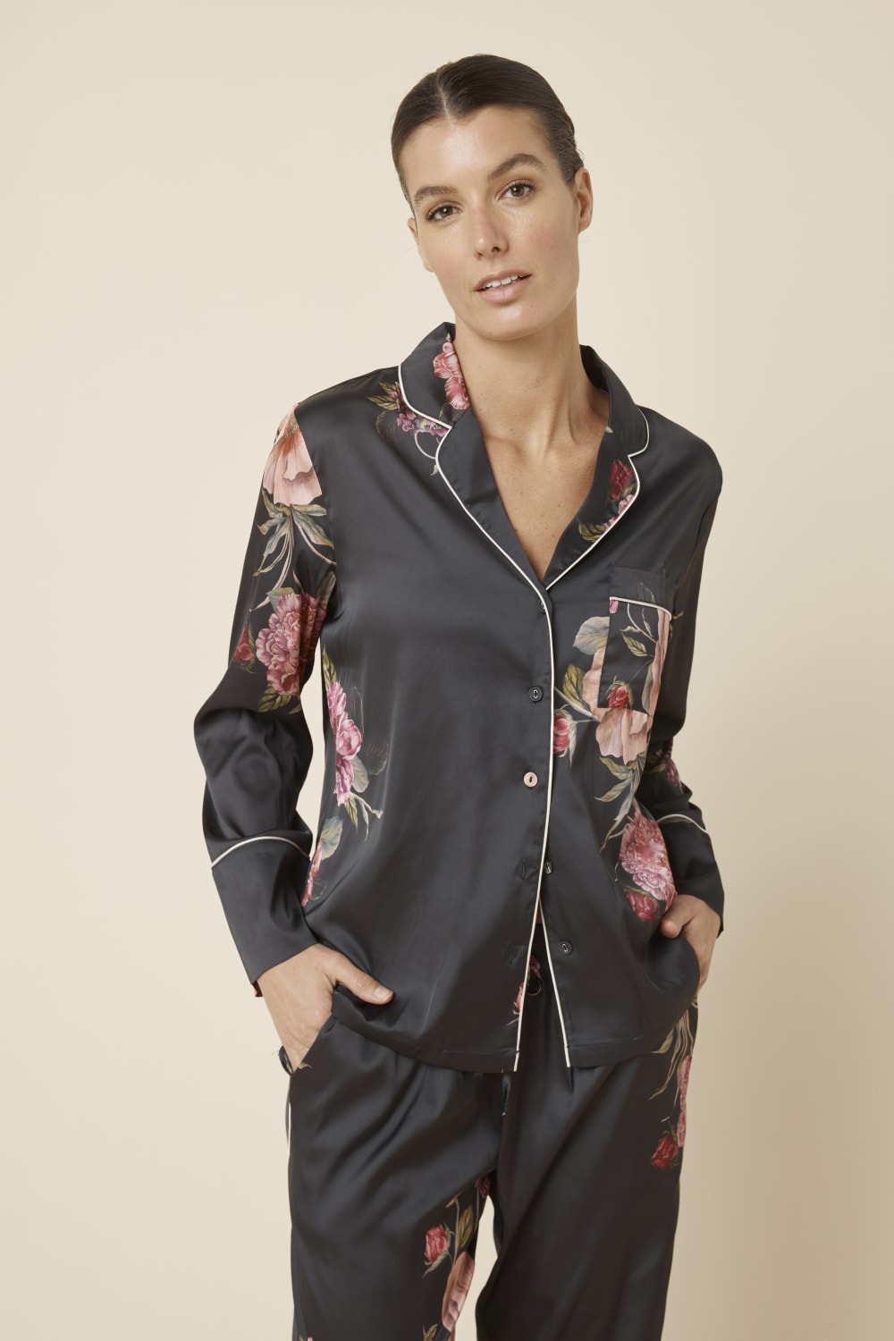 Woman wearing a Ruby Floral Satin PJ set black colour front top view on a beige background