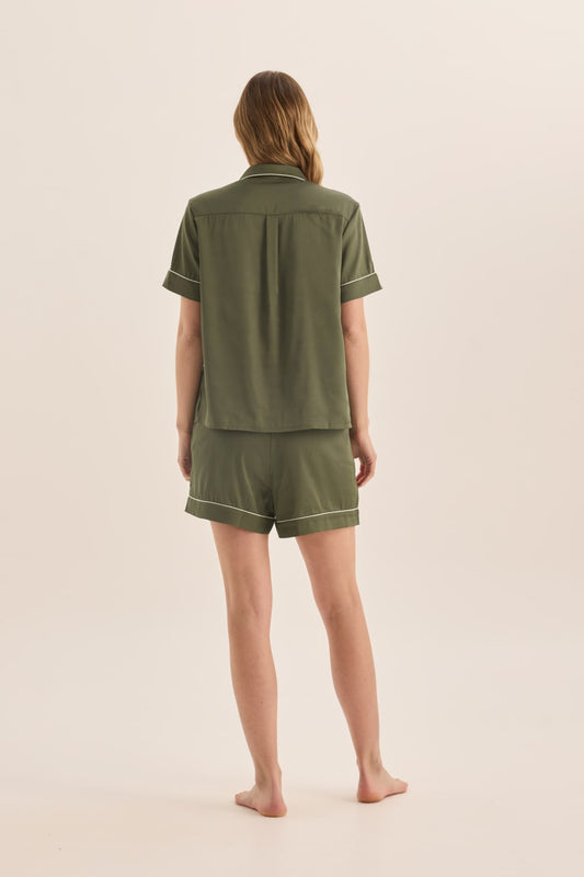 Person wearing a green pajama set on a beige background