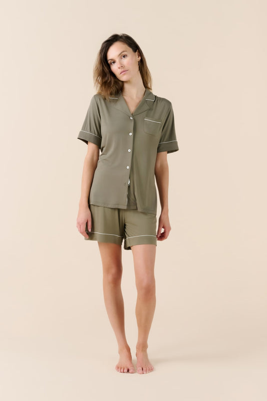 Woman wearing a green pajama set on a beige background
