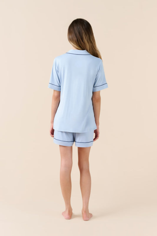 Person wearing a light blue pajama set on a beige background