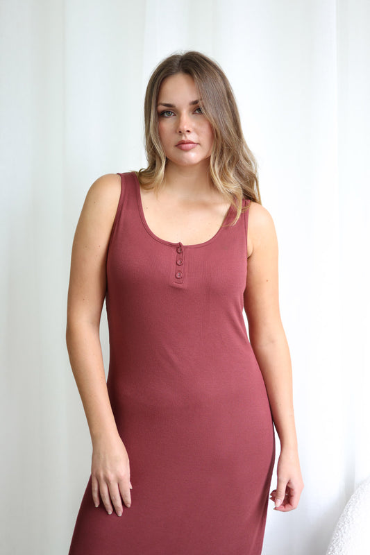 Woman wearing a burgundy sleeveless dress against a white background