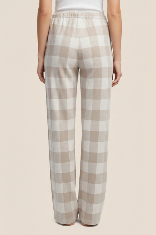 Back view of plaid sarita buffalo check wide front pyjama pants worn by a woman on a beige background