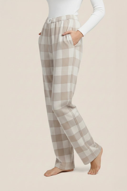 Sarita buffalo Check Wide side view of these plaid pajama pants worn by a woman on a beige background