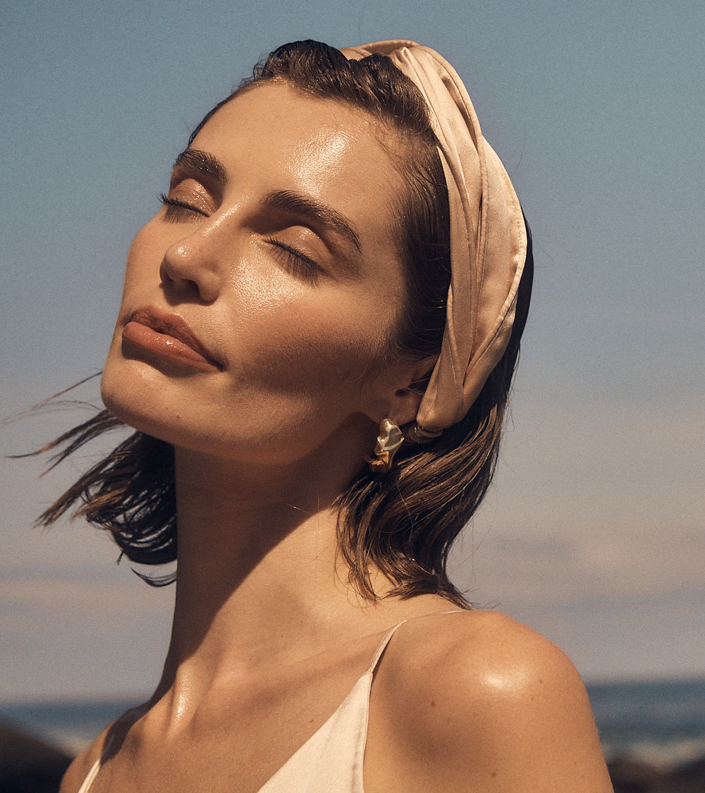 Woman with a headscarf against a clear sky