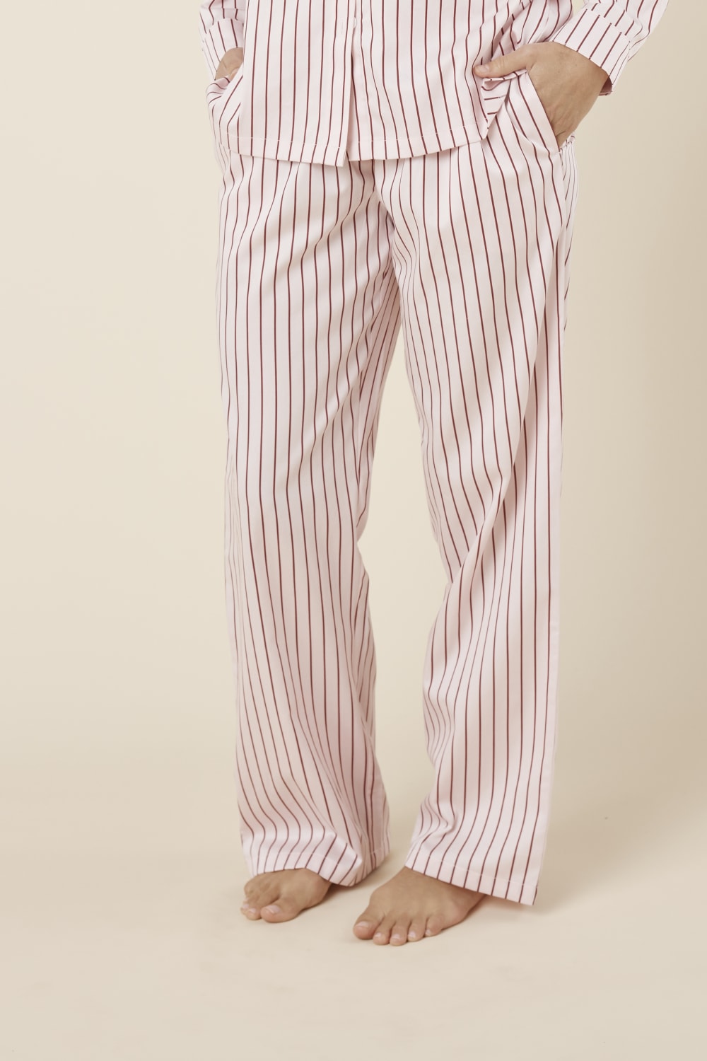 Willow Cotton Striped Pyjama Pants in Pink worn by a person on a beige background