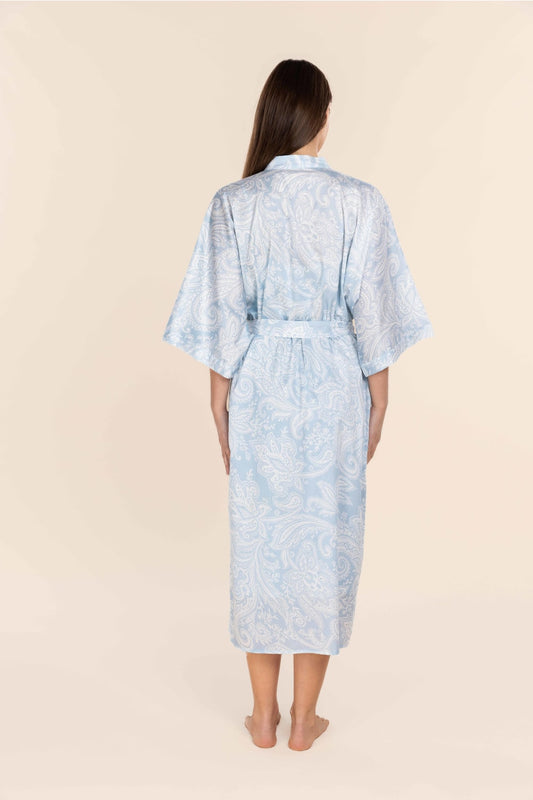 Woman wearing a light blue patterned robe on a beige background