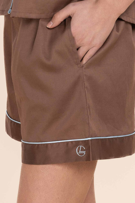 Brown shorts with a logo on a beige background