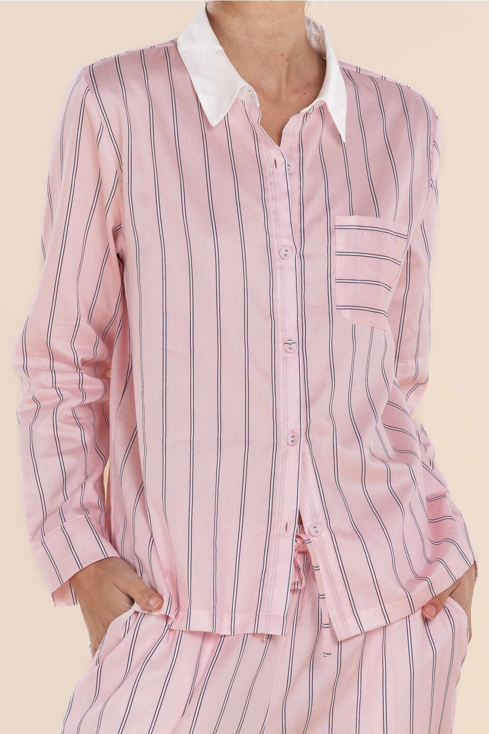 Pink striped pajama set with a white collar on a beige background