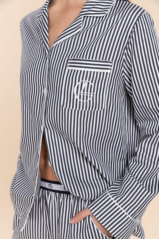 Black and white striped shirt with a logo on a beige background