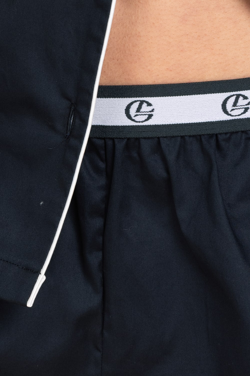 Navy blue shorts with a white waistband featuring a logo.