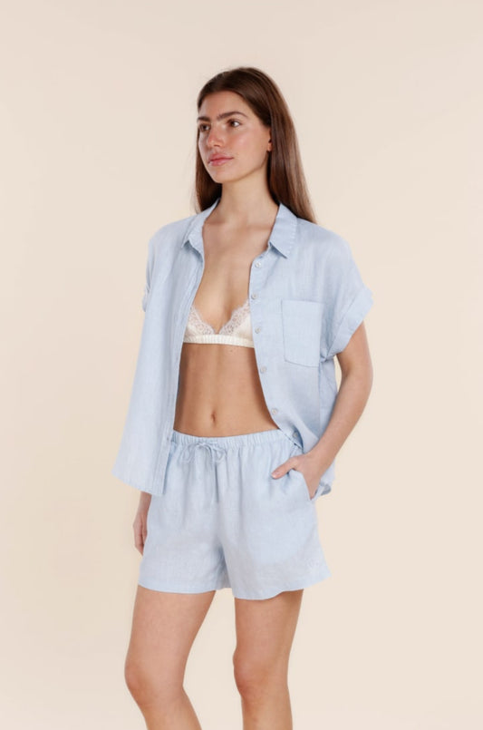 Woman wearing a light blue pajama set on a beige background