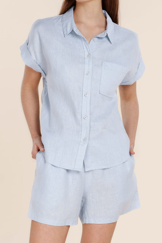 Light blue short-sleeve shirt and shorts set on a beige background