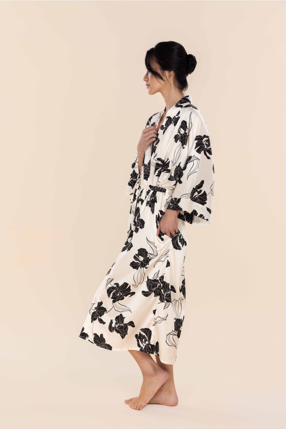 Woman wearing a black floral robe on a beige background