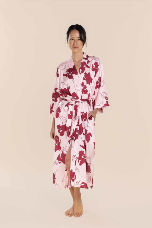 Woman wearing a pink floral robe on a beige background