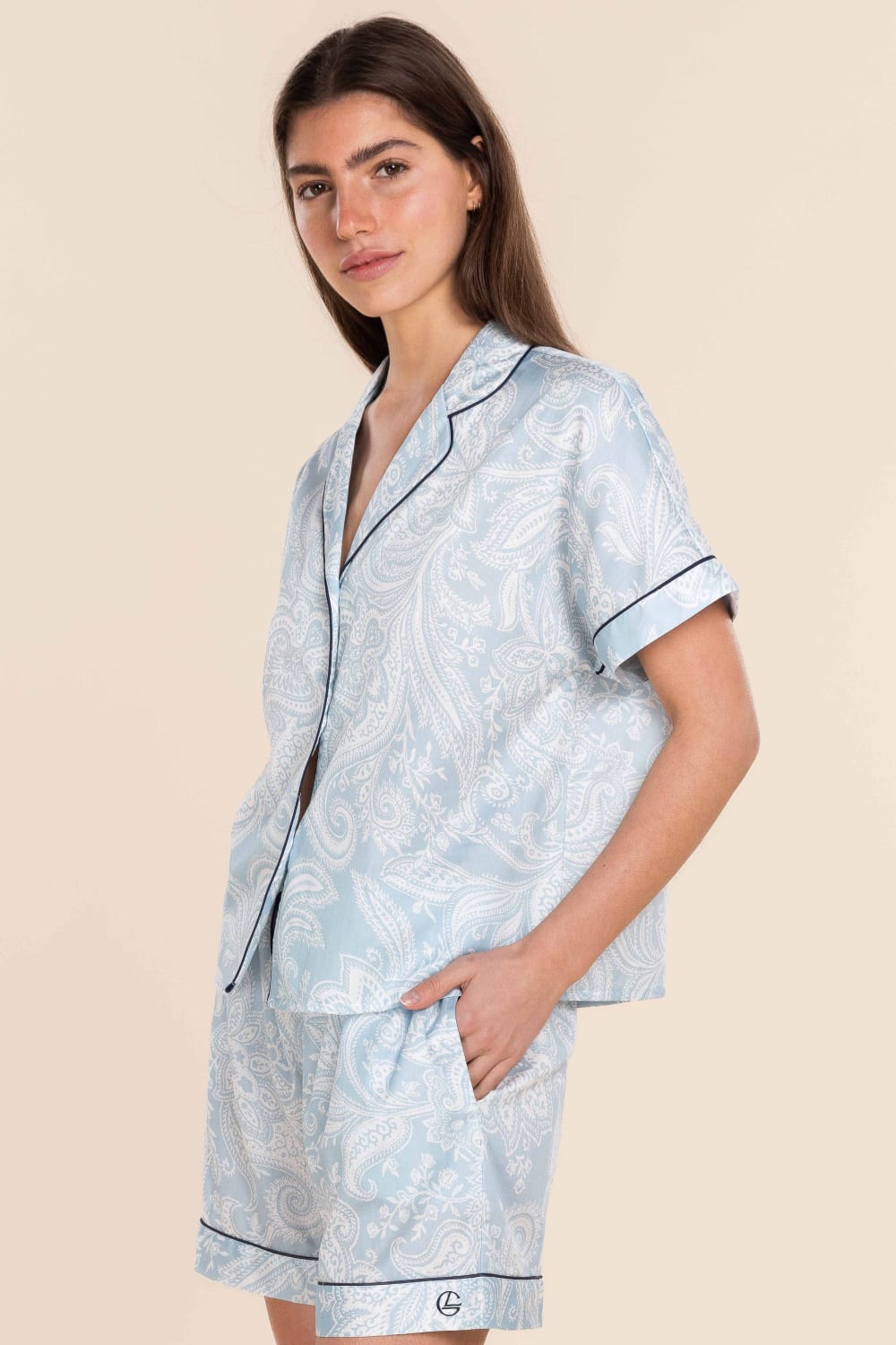 Woman wearing a light blue pajama set with a beige background