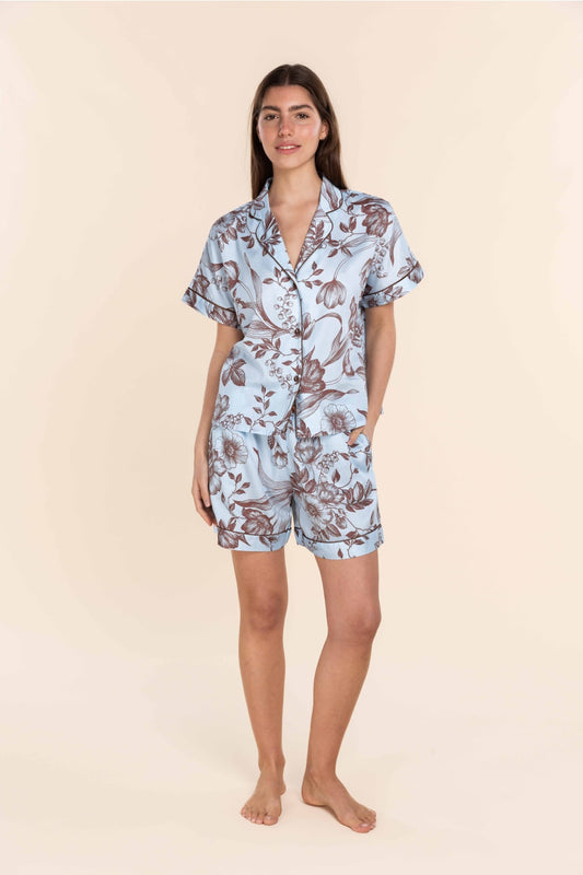 Woman wearing a floral pajama set on a beige background