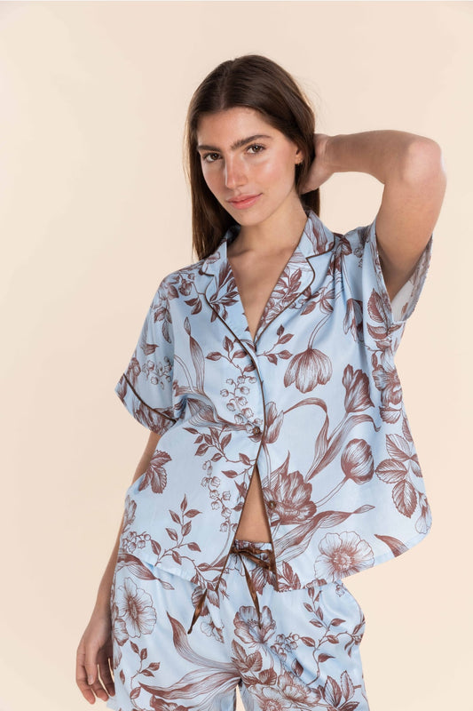 Woman wearing a floral pajama set on a beige background