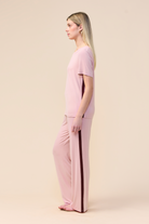 Woman wearing the Inez Bamboo Pant with Stripe in Pink, side view showing the contrast side stripe