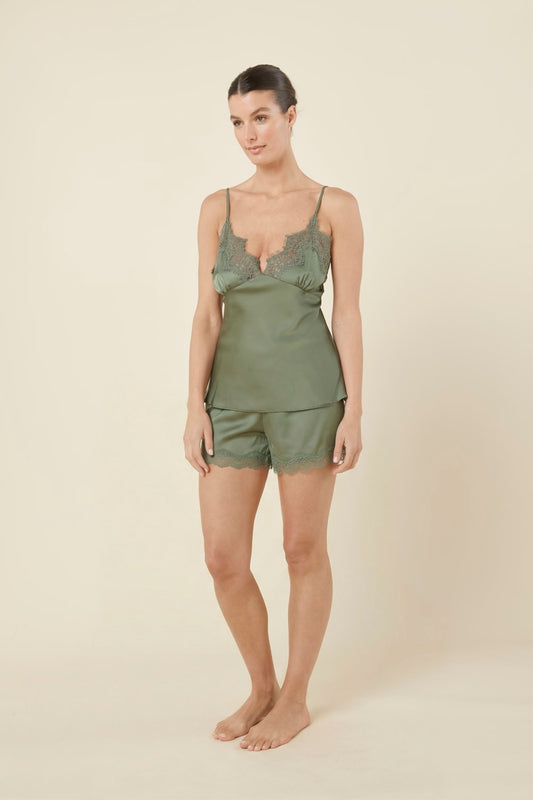 Woman front side on view wearing a green olive heather silky satin cami and short set with lace detail on a beige background