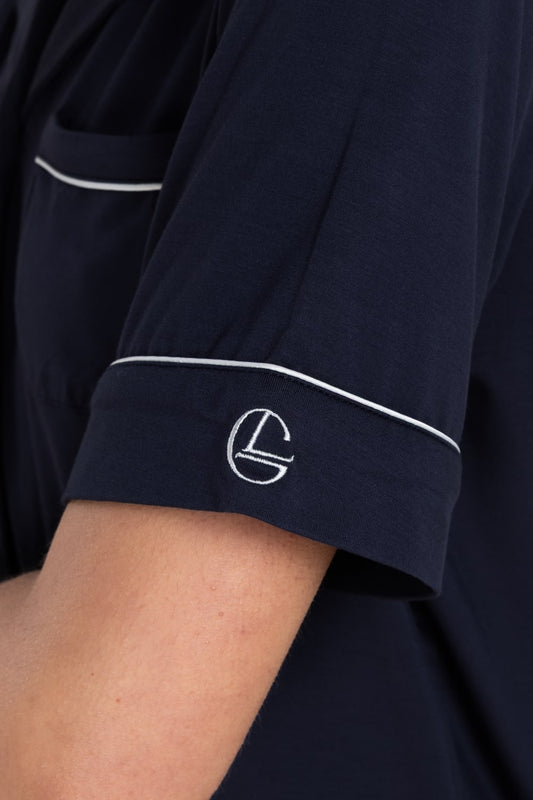 Navy blue shirt with white piping and a logo on the sleeve