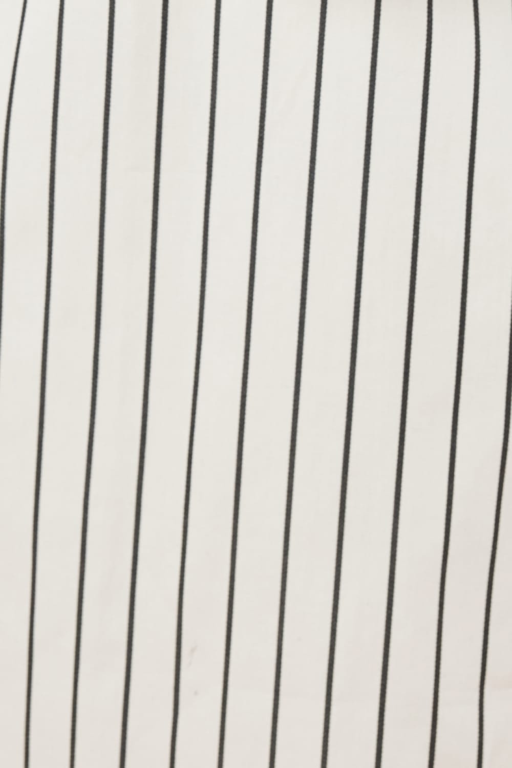 Close-up of a fabric with black vertical stripes of the lolita stripe night shirt in black and ecru ivory stripe.