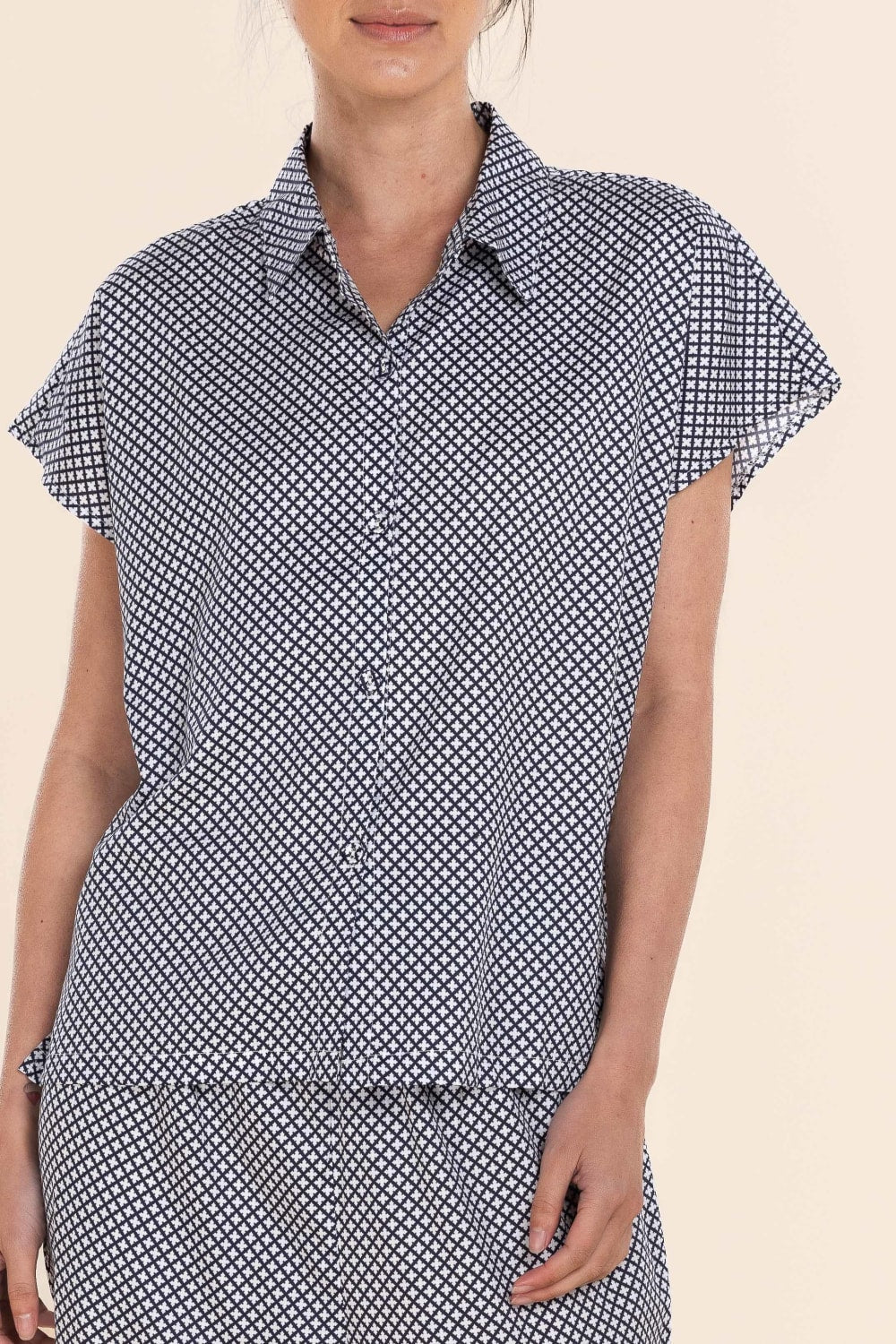 Woman wearing a black and white patterned dress on a beige background