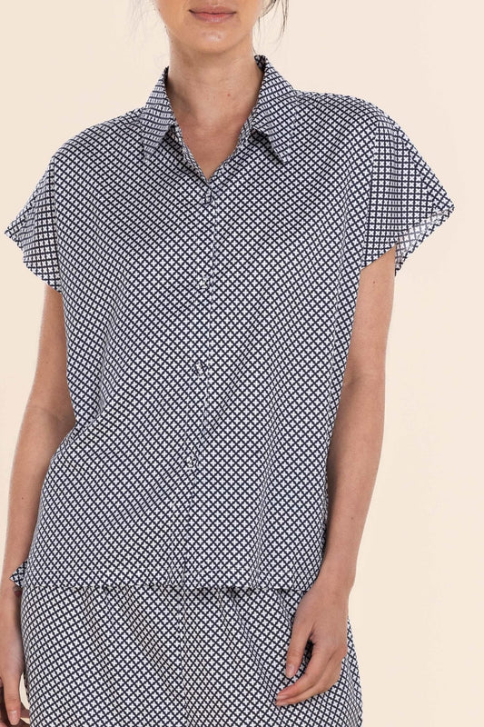 Woman wearing a black and white patterned dress on a beige background