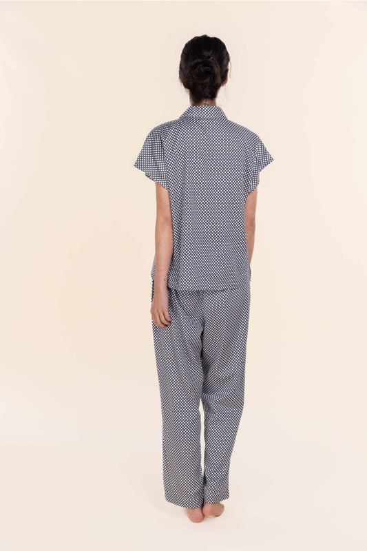 Person wearing a blue and white checkered pajama set on a beige background