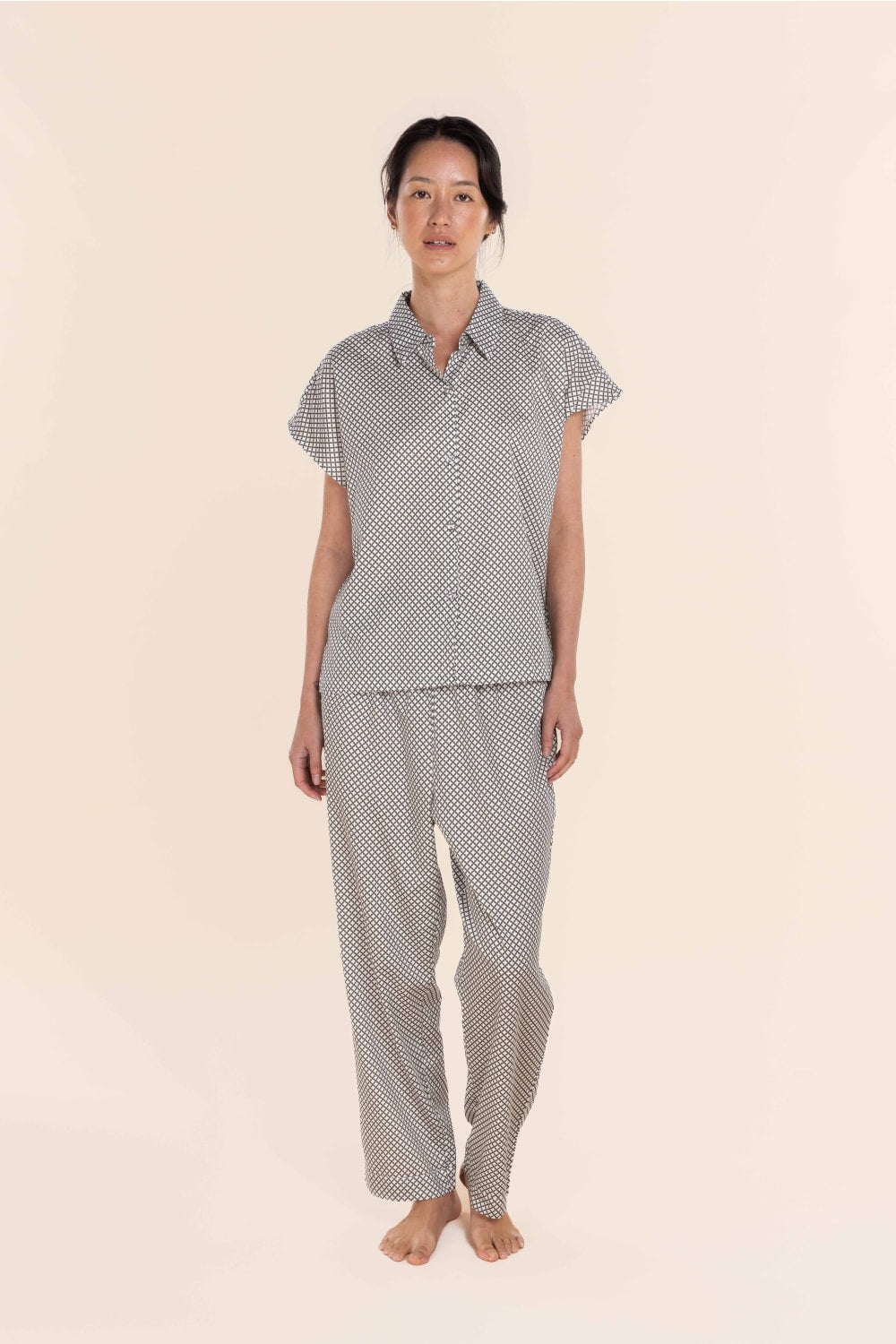 Woman wearing a patterned pajama set on a beige background