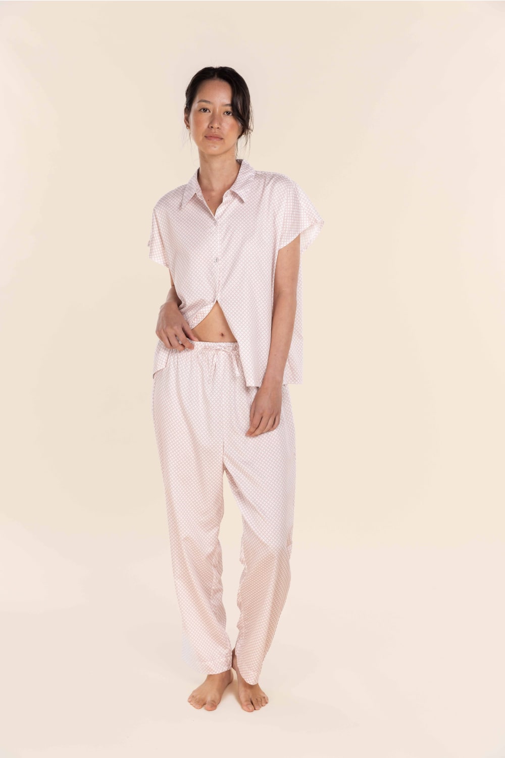 Person wearing a white shirt and pants on a beige background