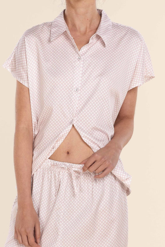 Person wearing a matching polka dot shirt and pants on a beige background