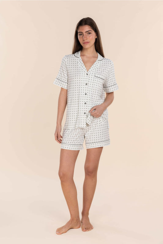 Woman wearing a white checkered pajama set on a beige background