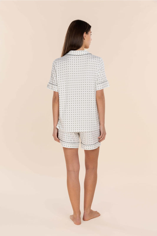 Woman wearing a patterned pajama set on a beige background