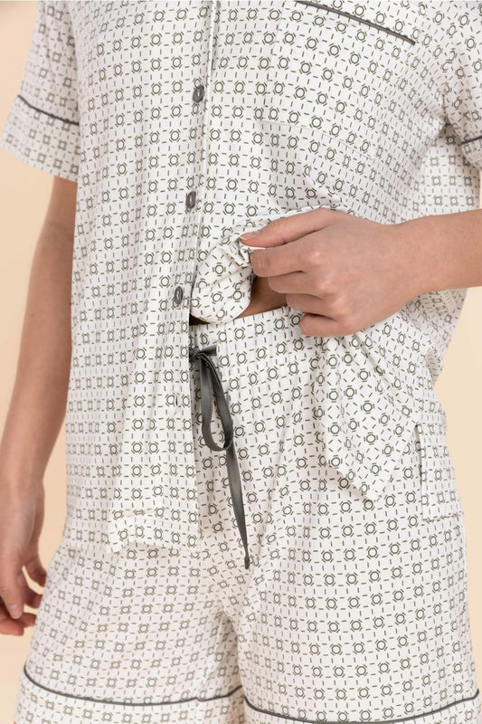 Patterned pajama set with a close-up of a hand adjusting the drawstring.