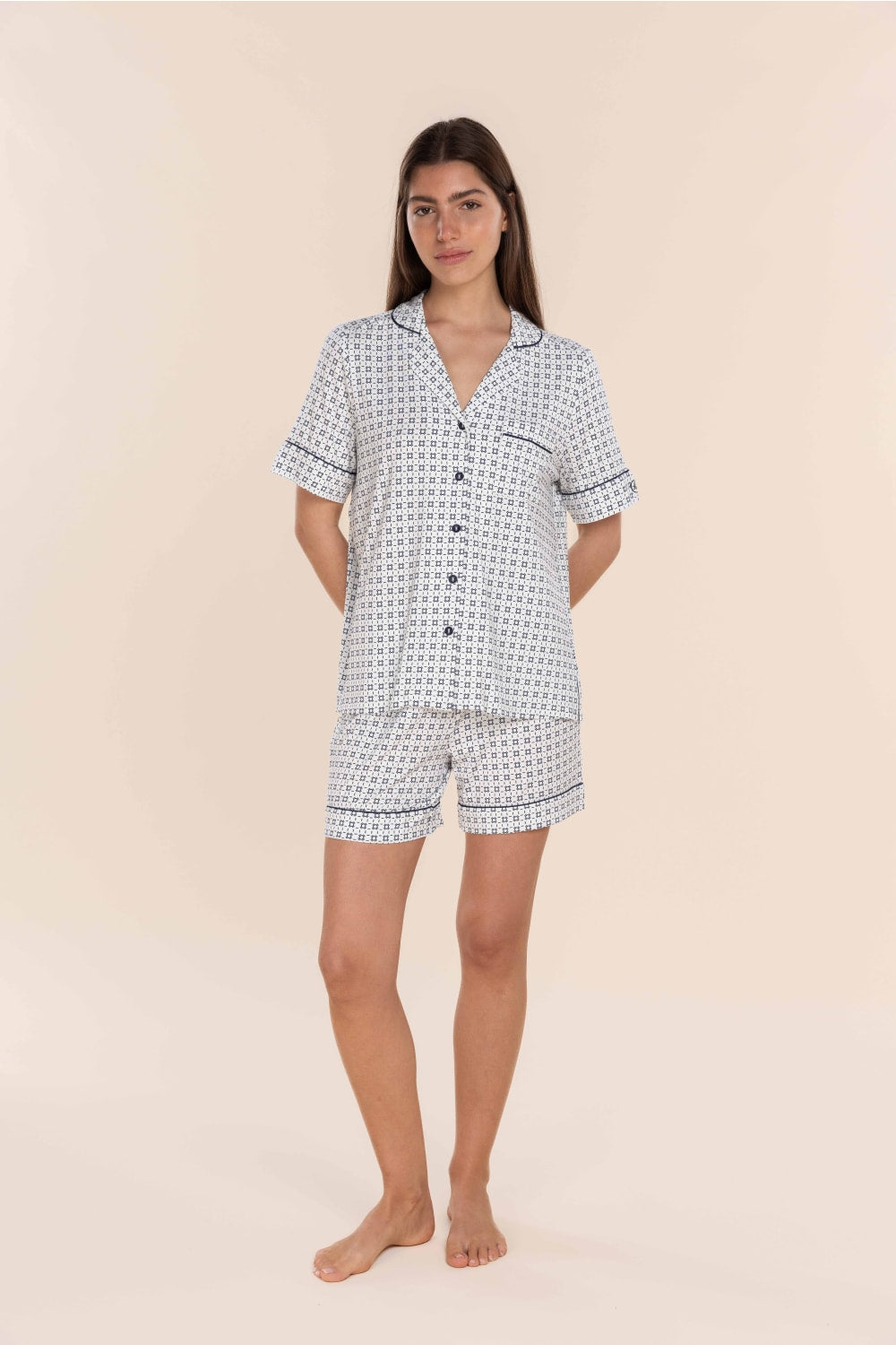 Woman wearing a patterned pajama set on a beige background