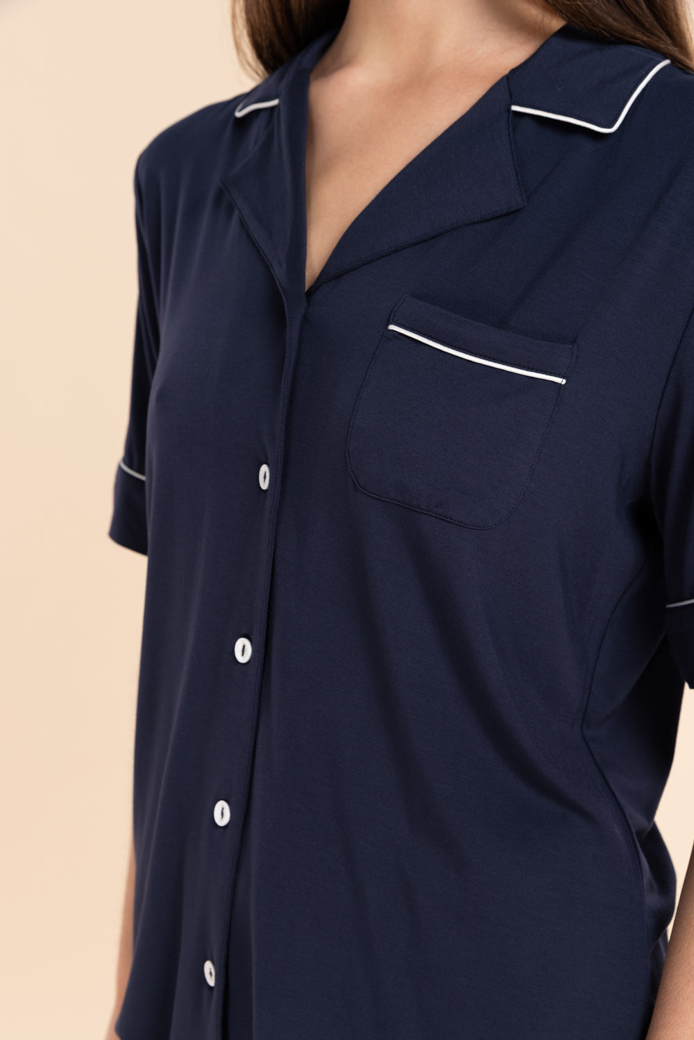 Navy blue shirt with white trim on a beige background