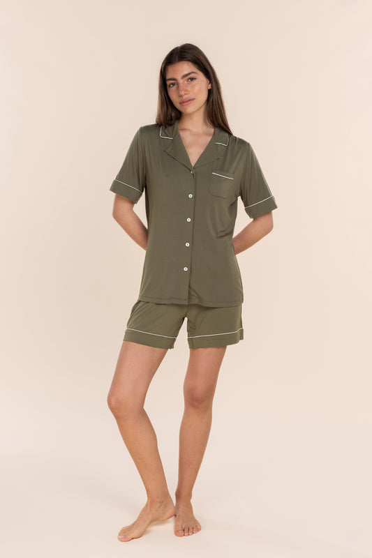 Woman wearing a green pajama set against a beige background