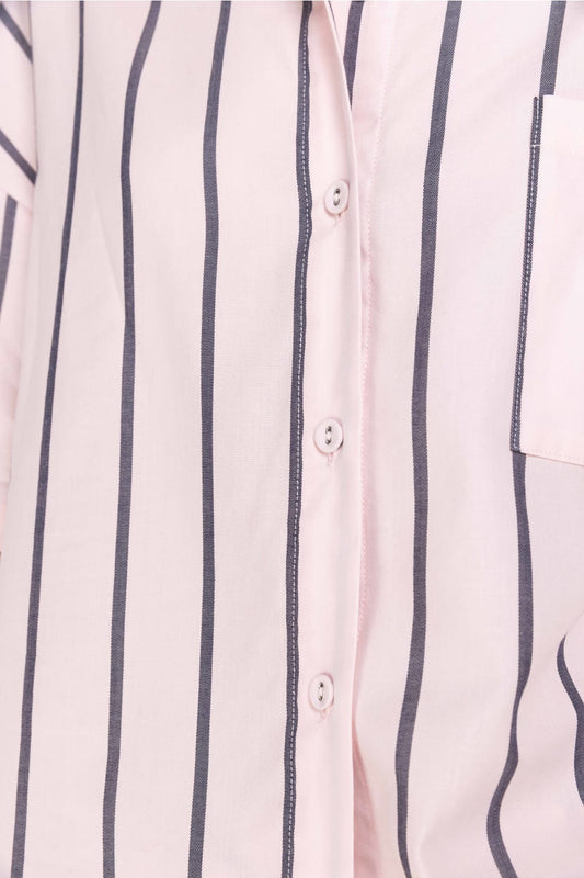 Close-up of a striped shirt with vertical navy lines on a light pink background
