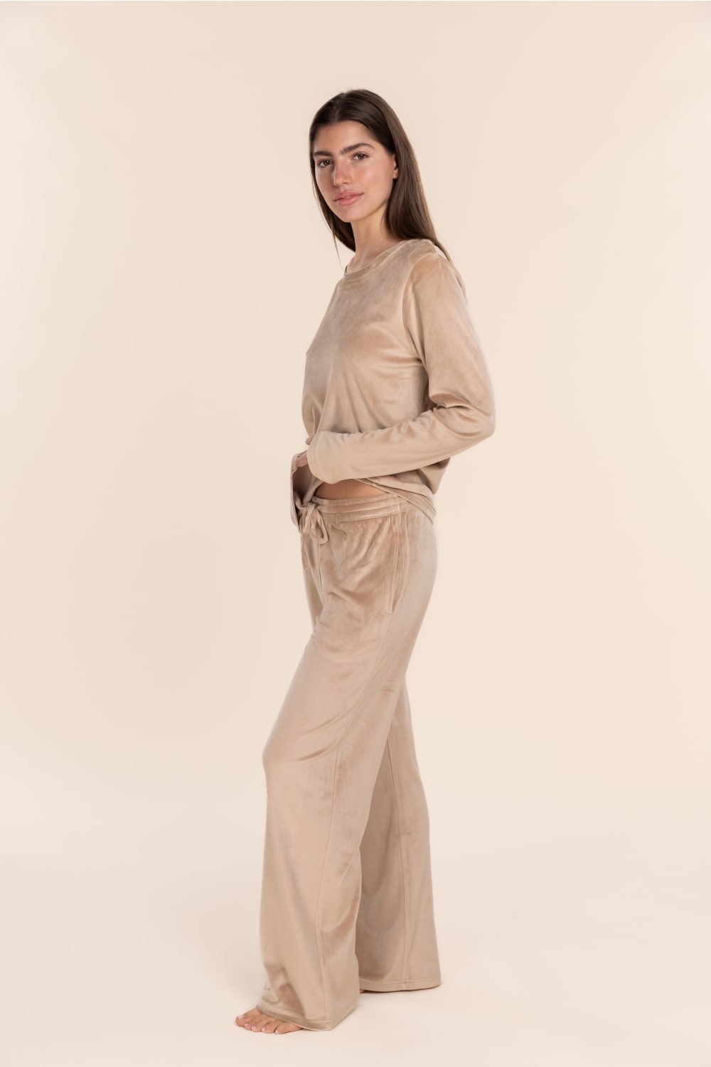 Woman wearing a beige outfit on a plain background