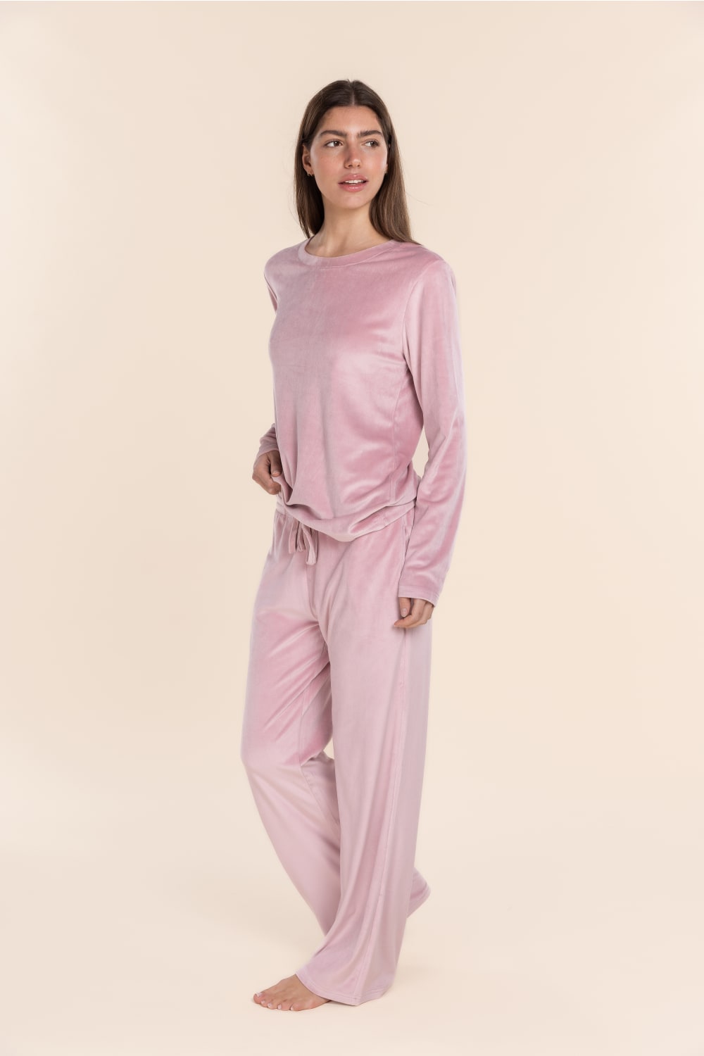 Woman wearing pink loungewear on a beige background