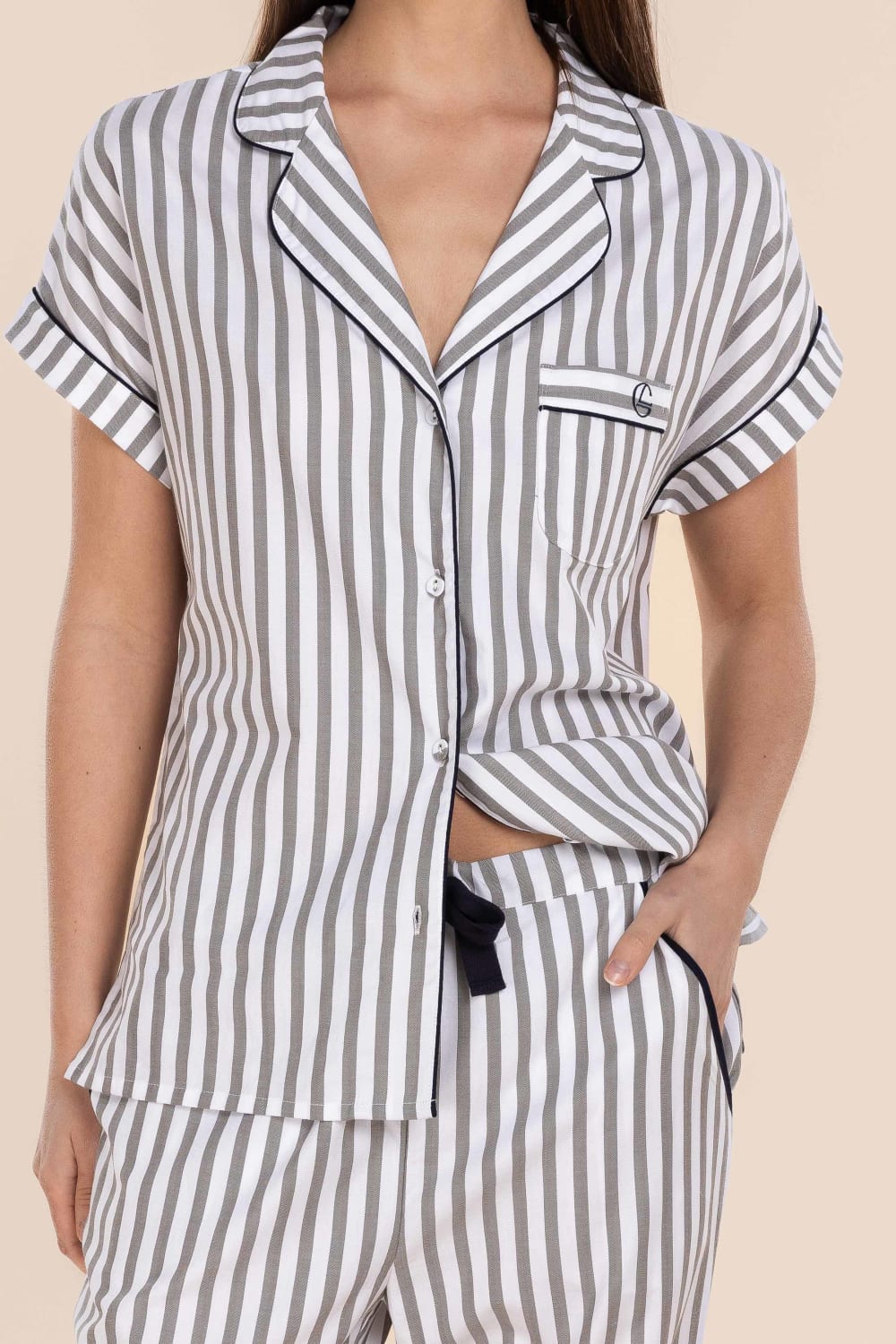 Striped pajama set worn by a person on a beige background