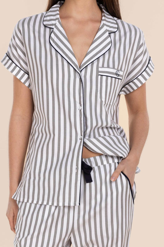 Striped pajama set worn by a person on a beige background