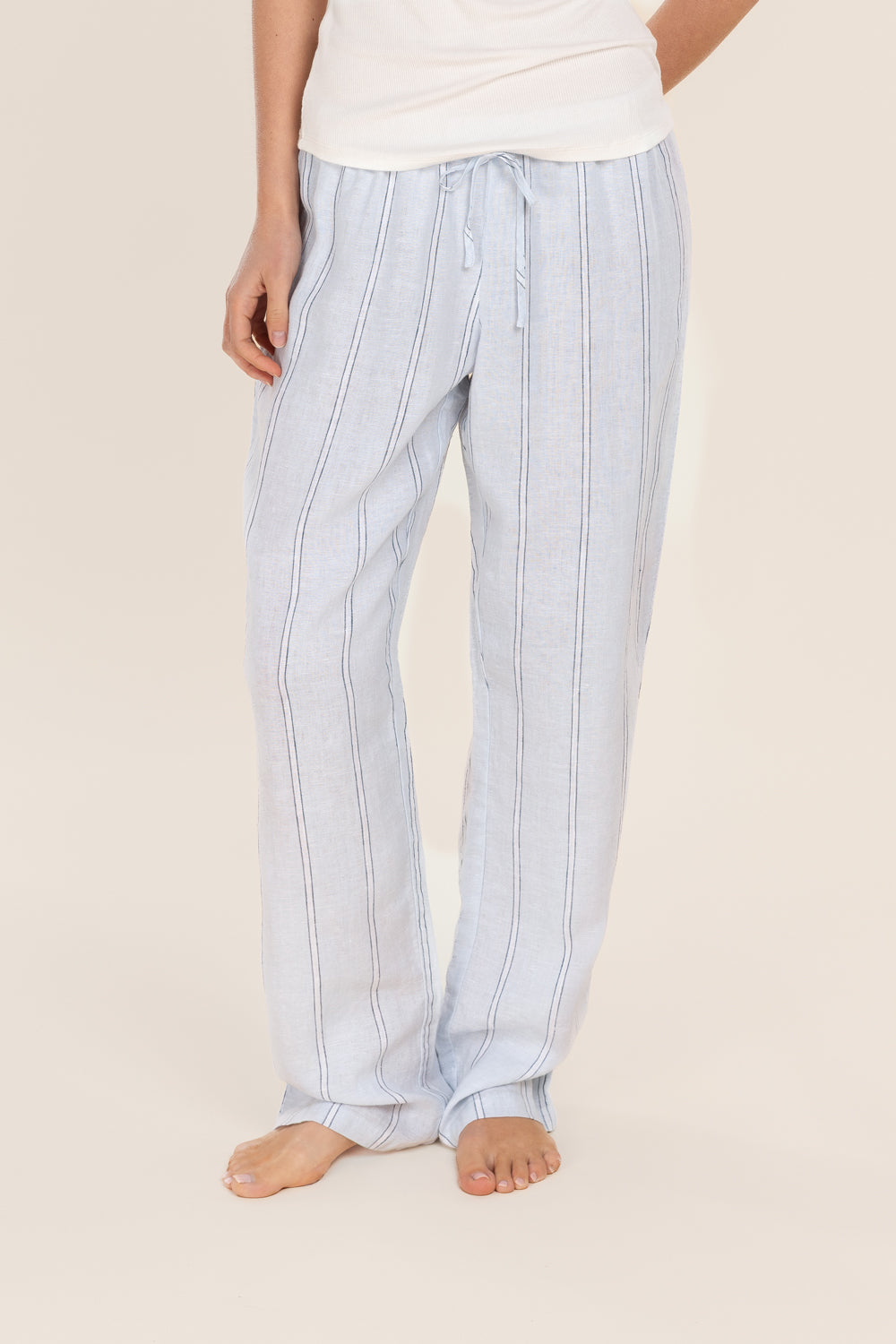 Light blue striped pants worn by a person on a beige background