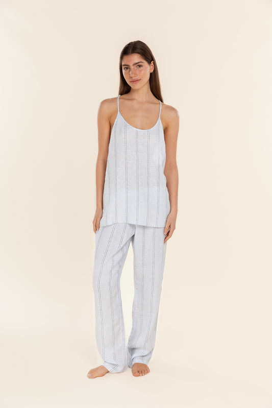 Woman wearing a light blue striped pajama set on a beige background