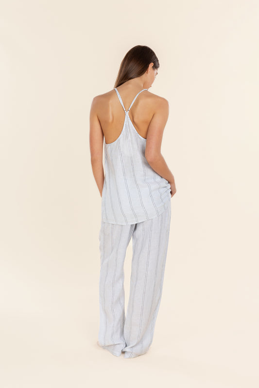 Woman wearing a light blue striped jumpsuit on a beige background