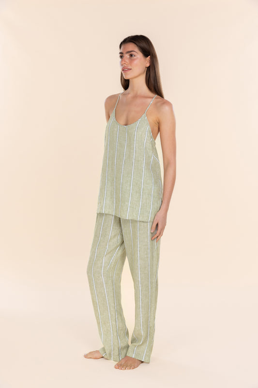 Woman wearing a green striped pajama set on a beige background