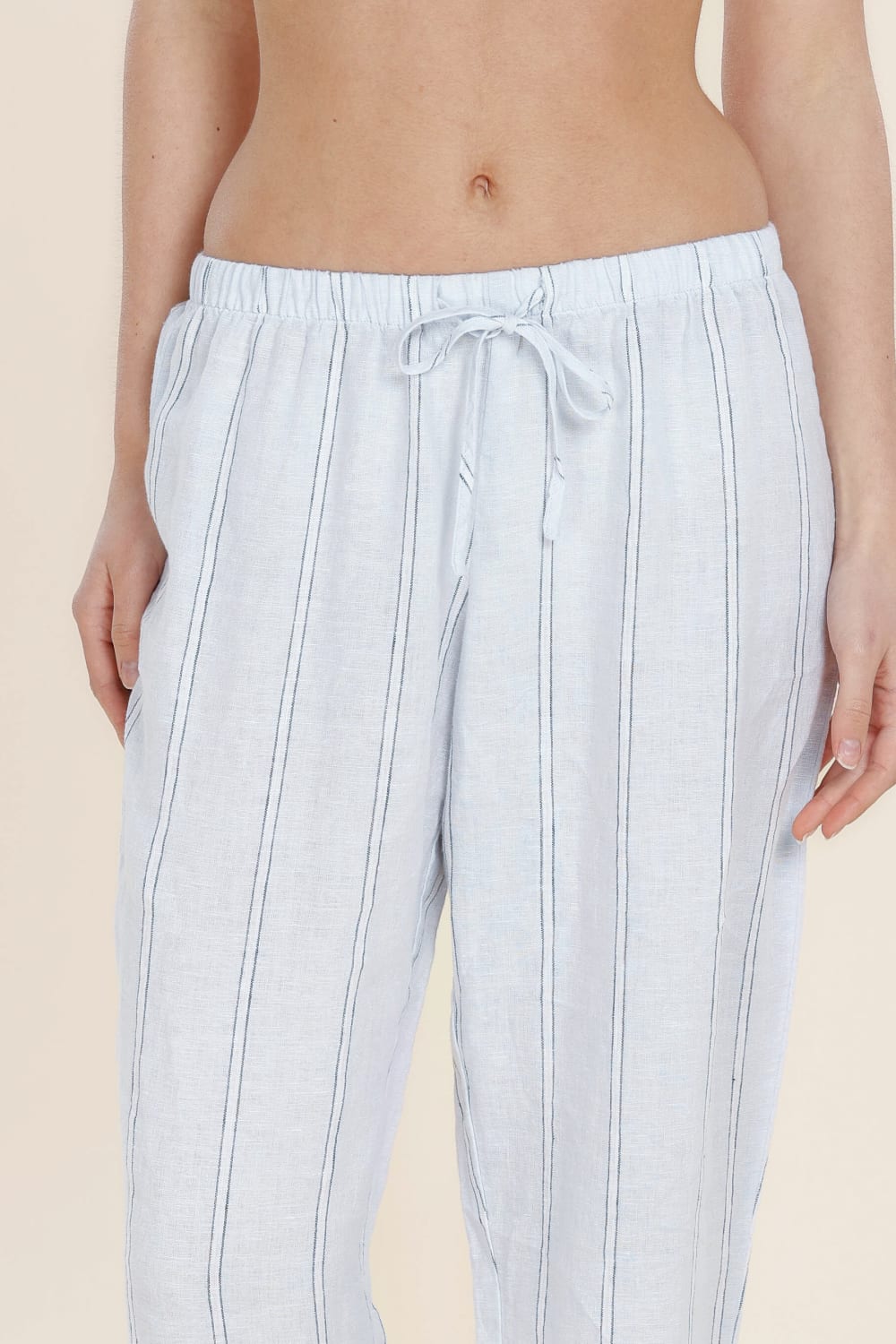 Light blue striped pants worn by a person on a beige background